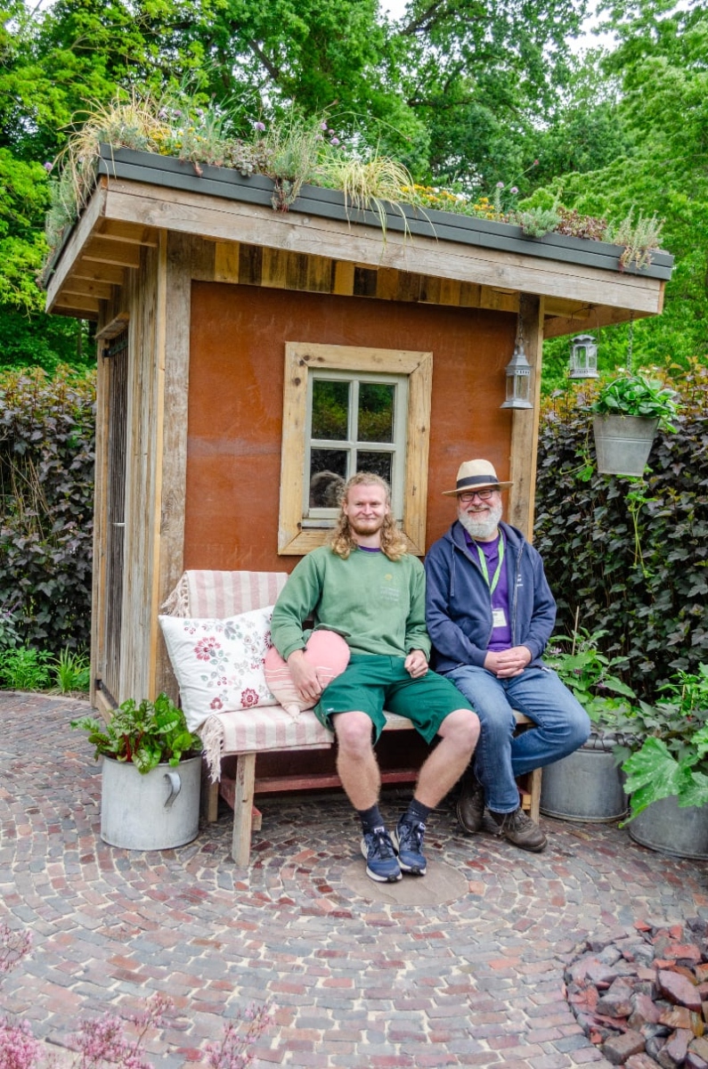 Jasper und Dirk auf der Bank vor der Hütte im grünen Refugium